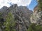 Limestone rock face of Gola Su Gorropu gorge with green bush and trees. Famous tourist hiking destination at Supramonte