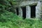 Limestone stone ruins. House, bushes and high grass