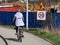 Limitation of traffic to 20 km/h near the construction site. A woman on a bicycle is driving along the sidewalk near the construct