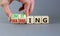 Limiting global warming symbol. Concept words Limiting and Warming on wooden cubes. Businessman hand. Beautiful grey table grey