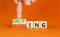 Limiting global warming symbol. Concept words Limiting and Warming on wooden cubes. Businessman hand. Beautiful orange table