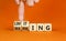 Limiting global warming symbol. Concept words Limiting and Warming on wooden cubes. Businessman hand. Beautiful orange table