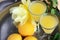 Limoncello in elegant liquor glasses with lemons, mint and yellow rose on steel plate. Sicilian lemon liquor