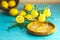 Limoncello with thyme in three grappas wineglass in wooden tray, fresh lemon in basket on light concrete table. Artistic still
