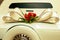 Limousine backside ornate with flowers. White wedding retro car closeup. Yellow toned.