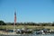 Limp American flag on flagpole over a parking lot.