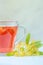 linden herbal tea in a transparent cup on a gray background