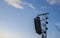 Line array speaker system hanging from pole during daylight performance