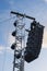 Line array speaker system hanging from pole during daylight performance