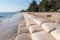 Line big sandbag prevent waves at Cha Am beach of Thailand.