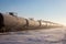 Line of Black Railroad Tank Cars in Winter With Snow and Blue Sky