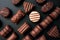 Line of chocolates of different shapes on a black background.