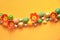 Line or curved border made of tulip flowers and Easter eggs. Easter flat lay on orange paper