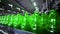 line for filling beer in a brewery. Empty green glass bottles moving on a conveyor belt in a queue at a beer factory.