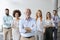 Line of happy and positive business people standing in the office