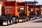 Line of heavy haulage orange trucks