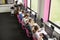 Line Of High School Students Working at Screens In Computer Class With Female Teacher In Background Shot From High Angle