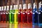 line of identical bottles filled with differently colored liqueurs