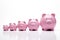 Line Of Large To Small Pink Piggybanks Or Savings Banks To Illustrate Inequality On White Background
