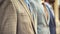 A line of mens suits neatly displayed in a row, showcasing professional attire for office workers