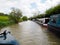 a line of moored narrowboats on the South Oxford canal seen from the bow of another boat