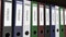 Line of multicolor office binders with Entries tags. 4K seamless loop clip