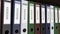 Line of multicolor office binders with Invoices tags. 4K seamless loop clip