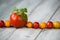 Line of natural organic red and yellow cherry tomatoes and tomato with fresh parsley on top on a wooden background