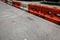 Line of orange and white hard plastic traffic barricades dividing a city street, crumbling asphalt roadway, creative copy space