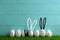 Line of painted Easter eggs on green lawn against wooden background