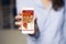 On line pizza shopping app in a mobile phone screen. Close up of woman hand holding the device.