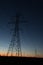 Line of power line towers around sunrise