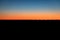 Line of Railway Cars Silhouetted Against Orange Sunrise