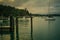 A line of seagulls perched on a pier. Small boats anchored nearby, Retro style