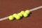 Line of seven yellow tennis balls on court