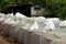 Line of temporary flood protection wall made of box barriers and sandbags covered with thick geotextile fabric and nylon used to