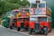 A line of vintage red and green vintage buses.