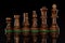 Line of wooden black chess pieces isolated at dark background