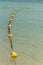 Line of yellow buoys on the rope floating in the sea