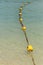 Line of yellow buoys on the rope floating in the sea