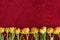 Line of yellow tulips on the red terry cloth bath towel