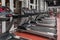 Lined contemporary speedwalks by the window in spacious, well lit, empty gym interior. Special modern equipment for
