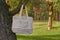 Linen bag with a bouquet of wildflowers hanging on a tree in the woods.