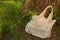 Linen bag with a bouquet of wildflowers, left in the woods under a tree trunk