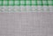 Linen cloth textile with lace lacy ribbon and border of green tartan pattern.