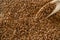 Linen seed, flaxseed - organic food background. Brown flax, linseed in wooden scoop for oil isolated dark stone. Vegan