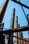 Lines of smokestacks, pipes, and girders silhouetted against a blue sky, old industrial complex