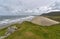 Lines of waves pounding the shelving sandy beach at Rhossili Bay in South Wales on the Gower Peninsula.