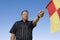 Linesman Showing Penalty Flag Against Blue Sky