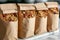 A lineup of bags filled with granola neatly arranged on top of a counter, House-made granola in craft paper bags, AI Generated